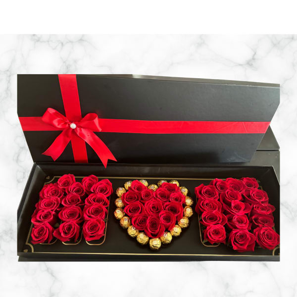 Black gift box with red roses and chocolates arranged in heart shapes