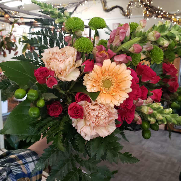 Bouquet of pink roses, peach carnations, and a peach gerbera daisy