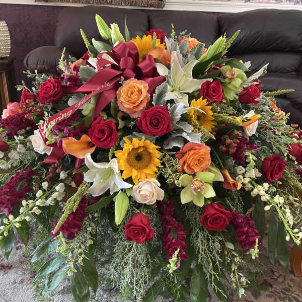 Large mixed flower arrangement with roses, lilies, and sunflowers