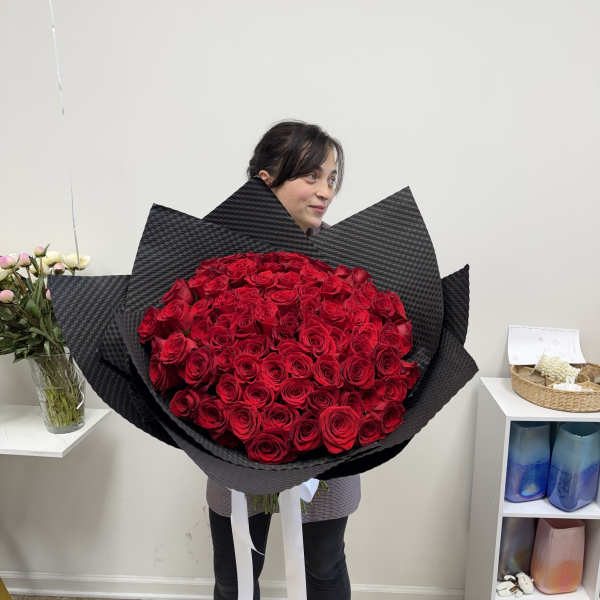 Large bouquet of red roses wrapped in black paper