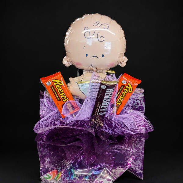 Baby-themed candy gift basket with a baby-face balloon topper