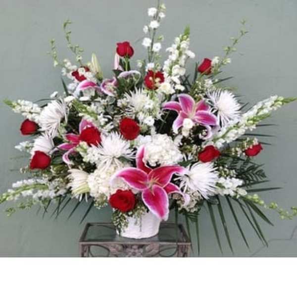 Large bouquet of red and pink flowers in a white vase