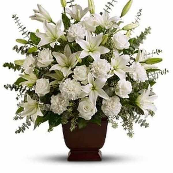 White lilies and roses arranged in a brown urn vase