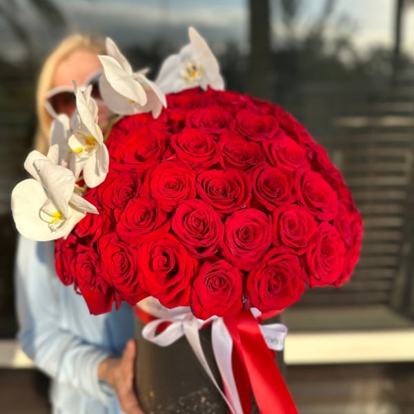 Large bouquet of red roses with white orchids in a black box