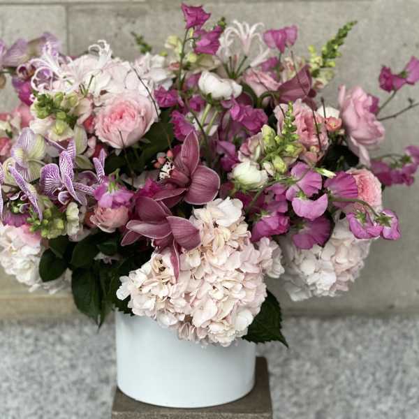 Pink and white mixed flower arrangement in a white vase