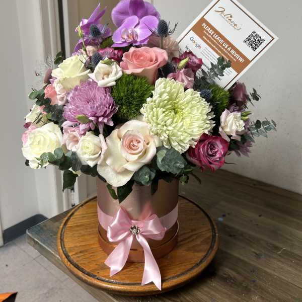 Mixed bouquet in a round hatbox with pink ribbon