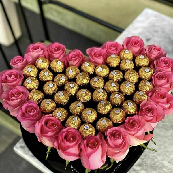 Heart-shaped box of pink roses filled with gold-wrapped chocolates