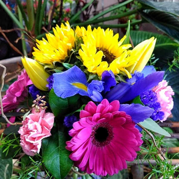 Bright mixed bouquet with sunflowers, gerbera daisies, irises, and carnations