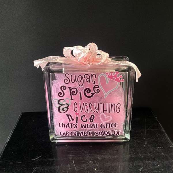Pink gift box with a ribbon and the words "Sugar, spice & everything nice"