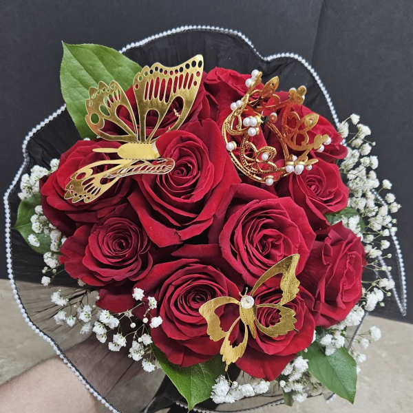 Bouquet of red roses with gold butterfly decorations and white filler flowers