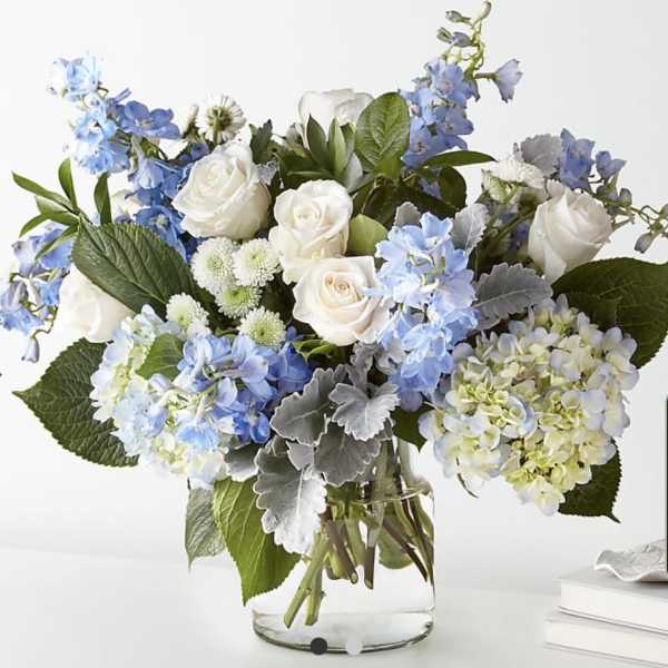 Blue and white flower arrangement in a clear glass vase
