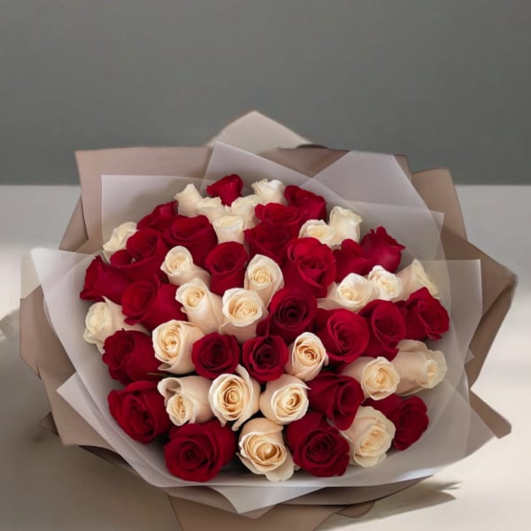 Bouquet of red and cream roses wrapped in layered paper