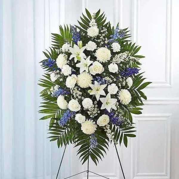 White and blue funeral spray on a standing easel