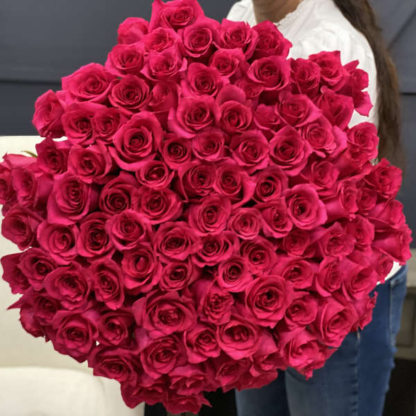 Large bouquet of hot pink roses held in front of a person