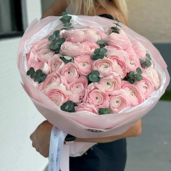 Bouquet of pale pink ranunculus wrapped in pink paper