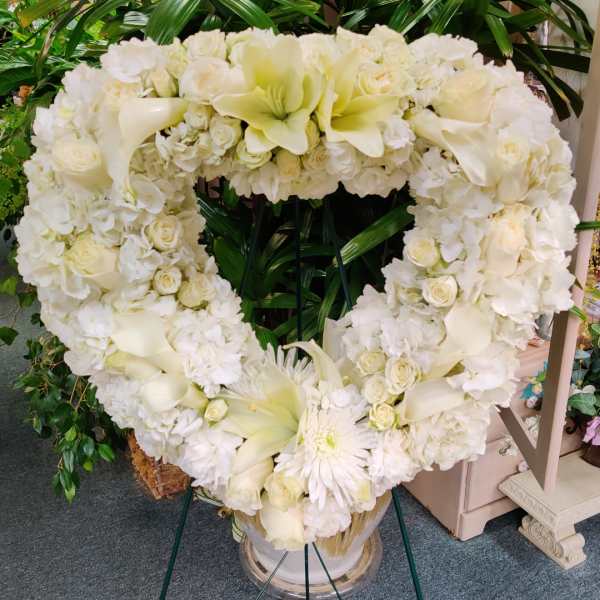 Large white floral heart arrangement on an easel