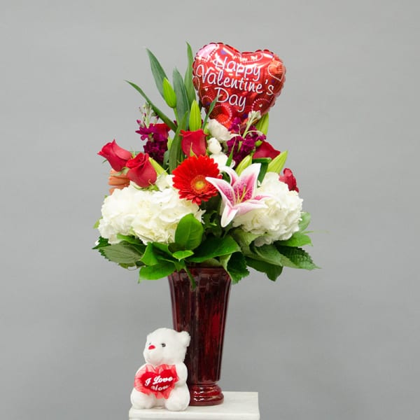 Valentine bouquet in a red vase with a teddy bear and heart balloon