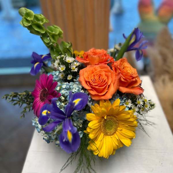 Mixed bouquet with orange roses, purple irises, and yellow gerbera daisies