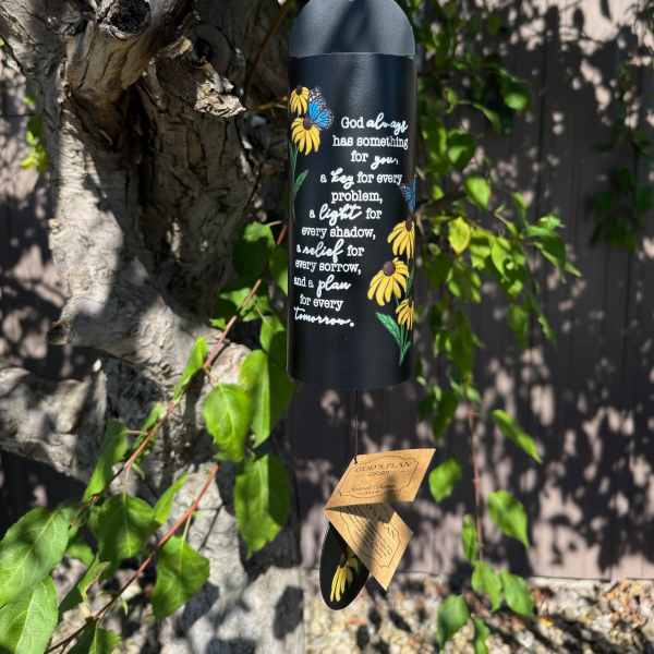 Black hanging wind chime with yellow flowers and white text