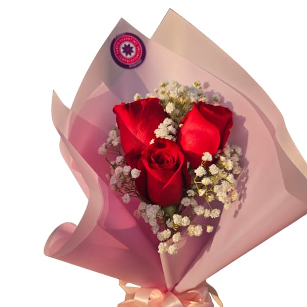 Bouquet of red roses with white baby's breath in pink wrap