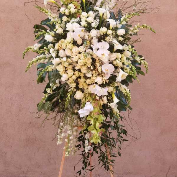 Tall white floral spray with orchids, roses, and calla lilies