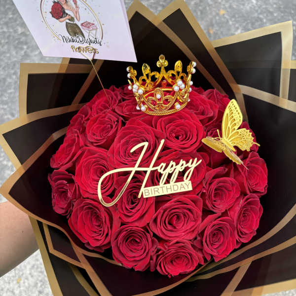 Bouquet of red roses with a birthday topper and crown