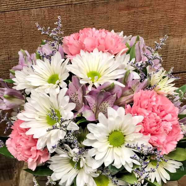 Bouquet of white daisies, pink carnations, and lavender flowers