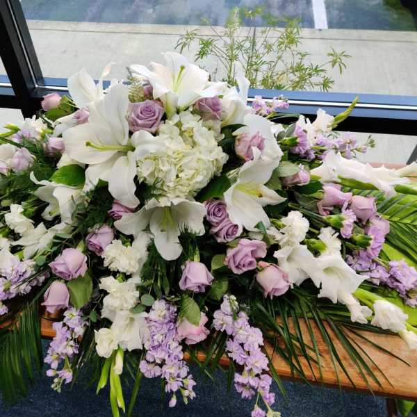 Large white and lavender floral arrangement with lilies and roses