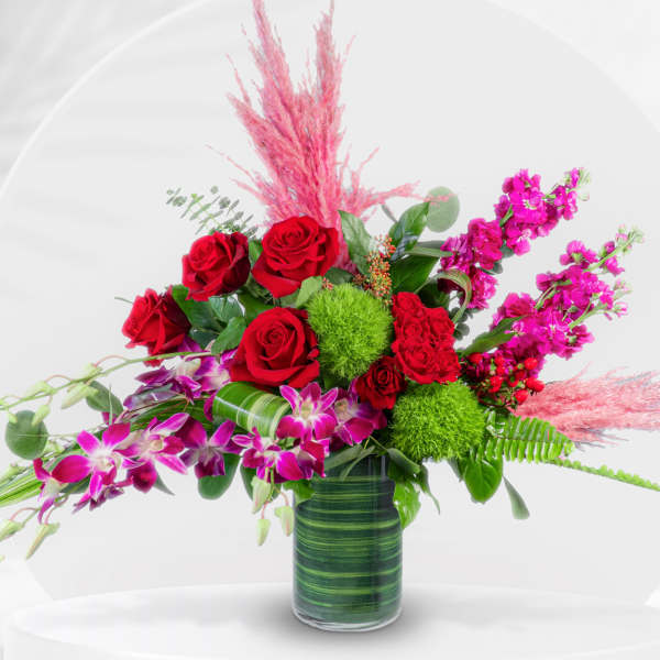 Red roses and pink orchids in a glass vase
