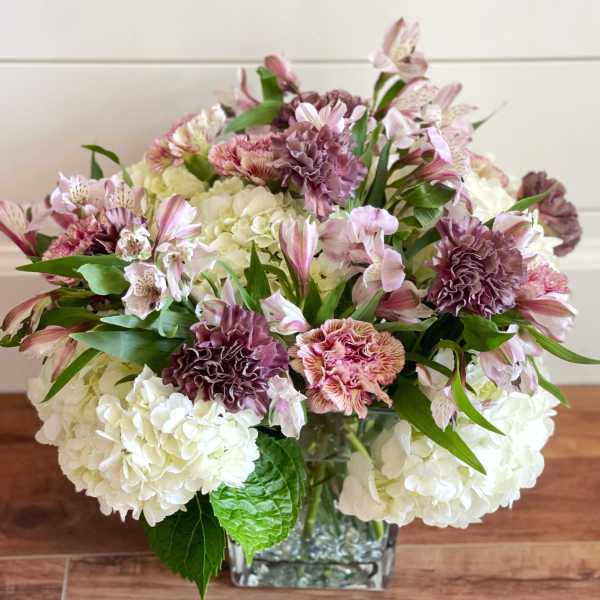 Bouquet of pink and white flowers in a square glass vase