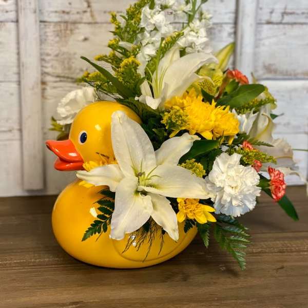 Yellow duck-shaped container filled with white and yellow flowers