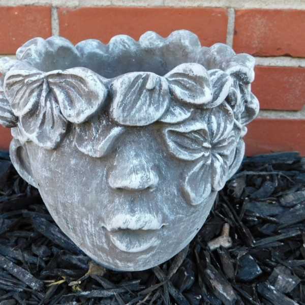 Stone face planter with floral crown detail