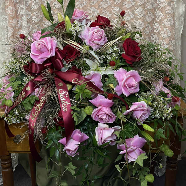 Large bouquet of pink and red roses with ribbon on a table
