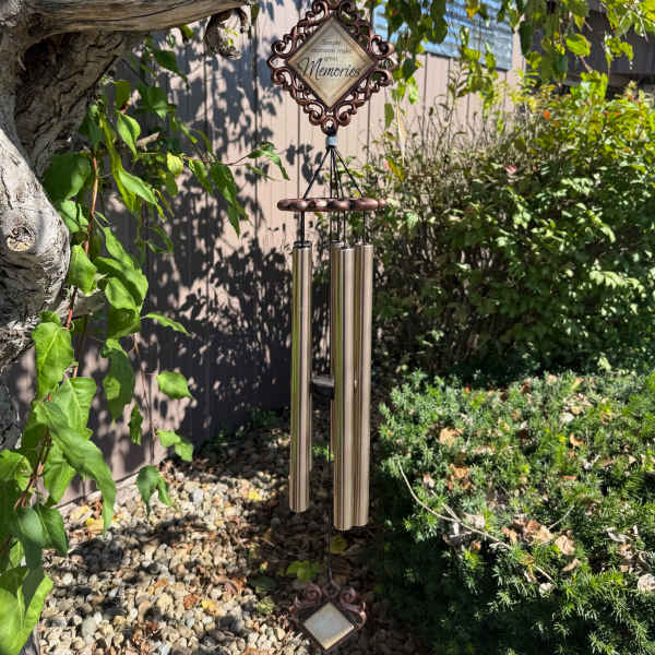 Decorative wind chime hanging from a tree in a garden