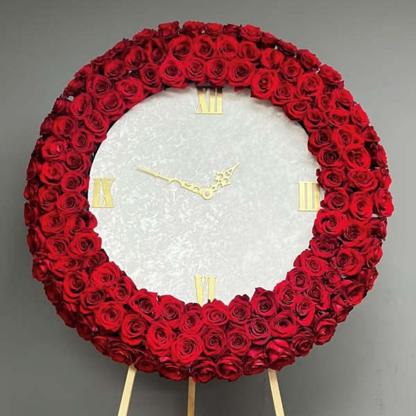 Red rose wreath arranged as a clock face on an easel