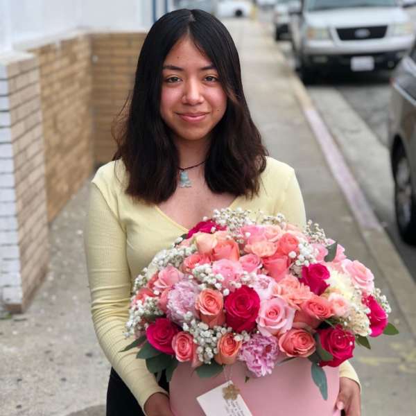 Woman holding a large pink box of mixed roses