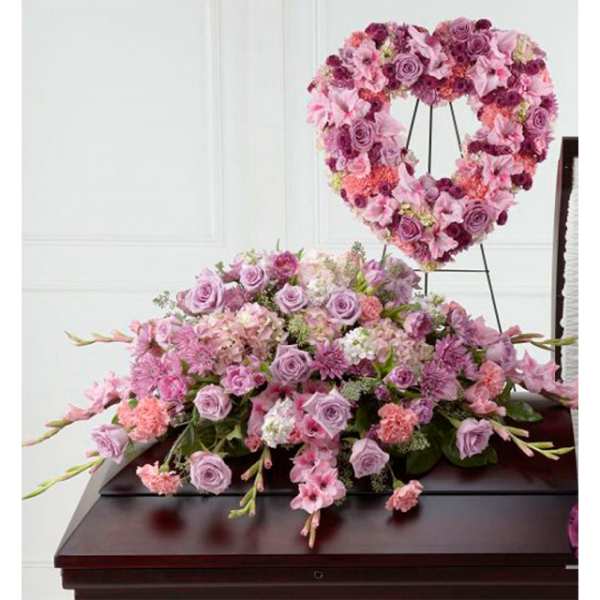 Pink and lavender funeral casket spray with matching heart-shaped standing wreath.