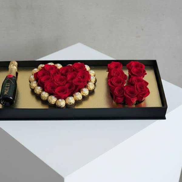 Gift tray with red roses, chocolates, and a small champagne bottle