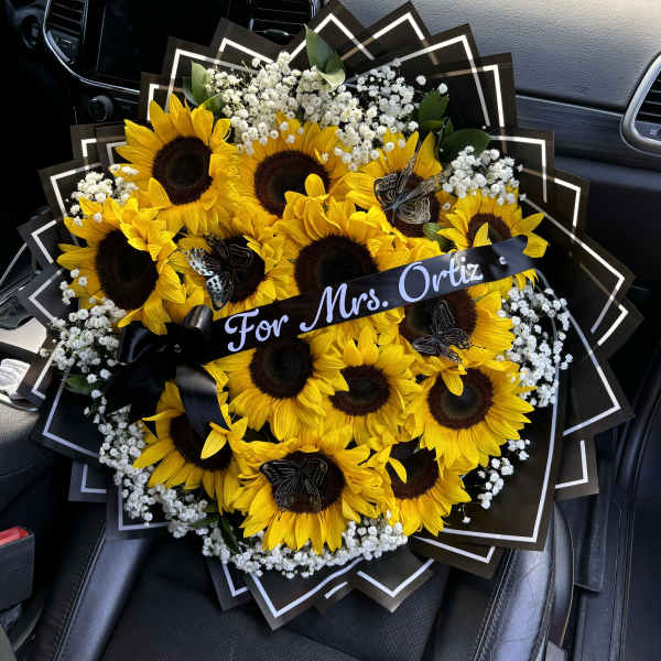 Bouquet of sunflowers and baby's breath with a black ribbon