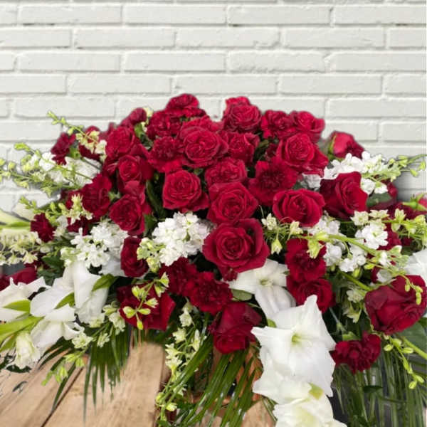 Large red and white floral arrangement with roses and lilies
