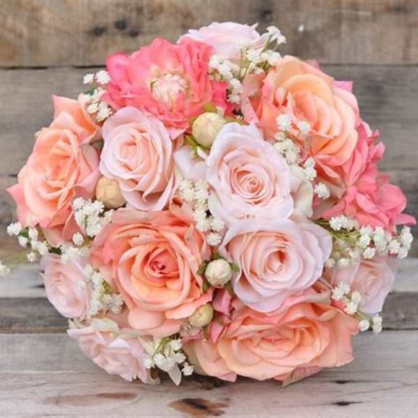 Bouquet of blush and peach roses with small white filler flowers