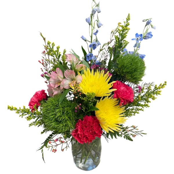 Mixed bouquet in a glass vase with yellow, pink, blue, and red flowers