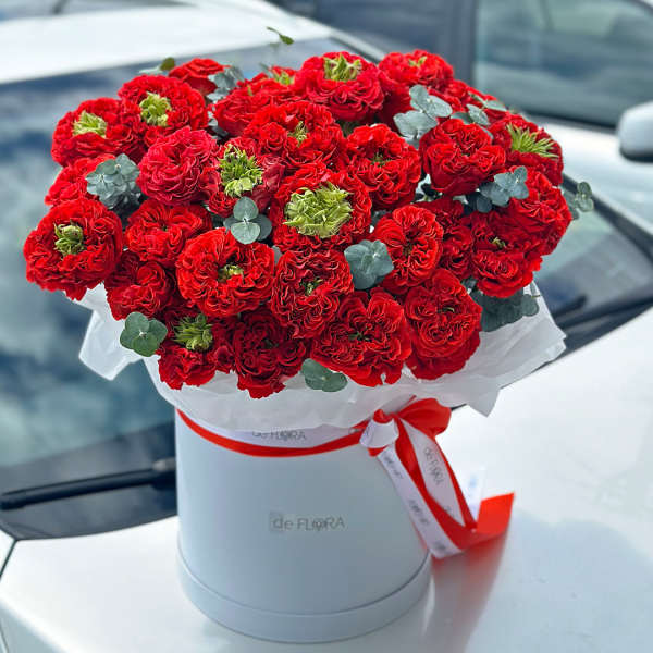 Red carnation bouquet in a white hat box with a ribbon