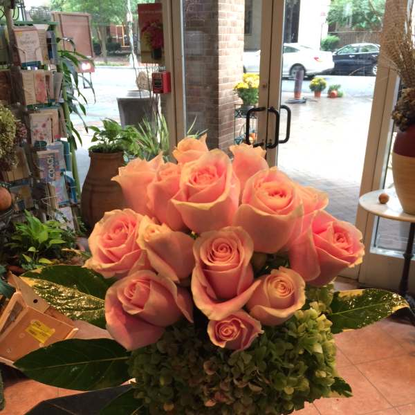 Pink roses arranged in a clear square vase