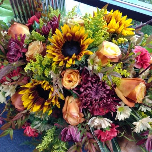 Mixed bouquet with sunflowers, roses, and chrysanthemums in warm autumn colors