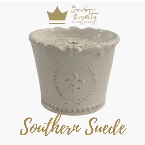 Cream-colored decorative candle in an embossed ceramic container