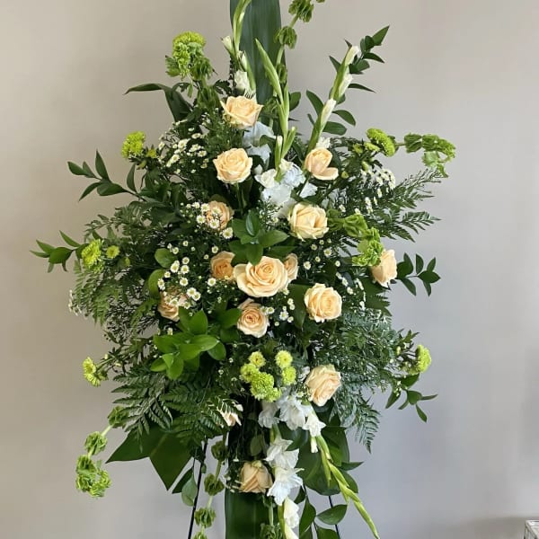 Tall floral standing spray with peach roses and white blooms