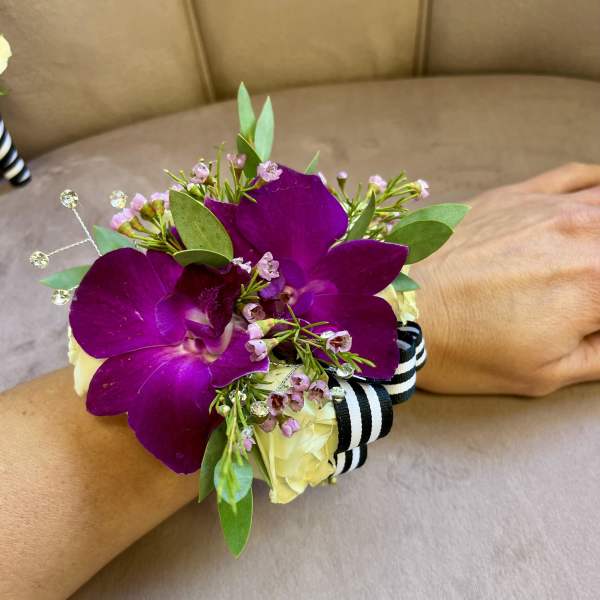 Purple orchid wrist corsage with cream roses and striped ribbon