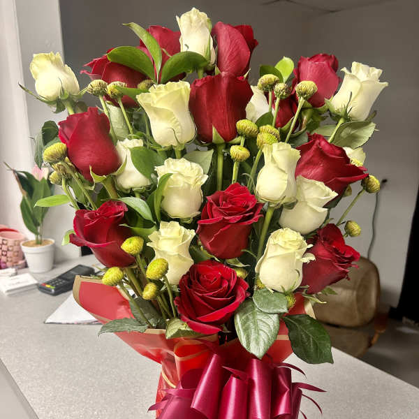 Bouquet of red and white roses in a red gift wrap with ribbon