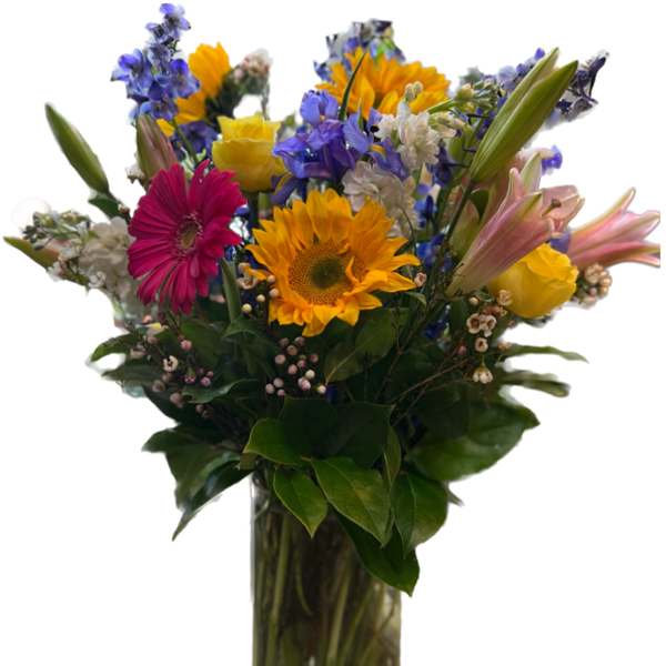 Mixed bouquet of sunflowers, lilies, and gerbera daisies in a glass vase